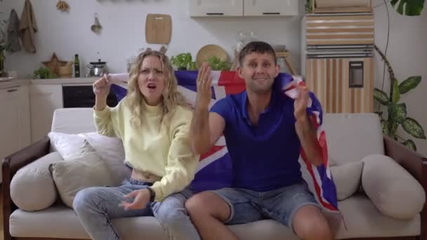 Una familia de fans de la selección del Reino Unido en casa con la bandera de Gran Bretaña. — Vídeos de Stock