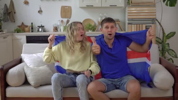 Rodzina fanów islandzkiej drużyny narodowej ogląda telewizję w domu z flagą Islandii — Wideo stockowe