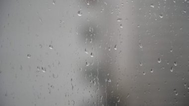 Yakın planda yağmur damlaları olan cam. Sonbahar, yağmurlu hava, pencereden manzara