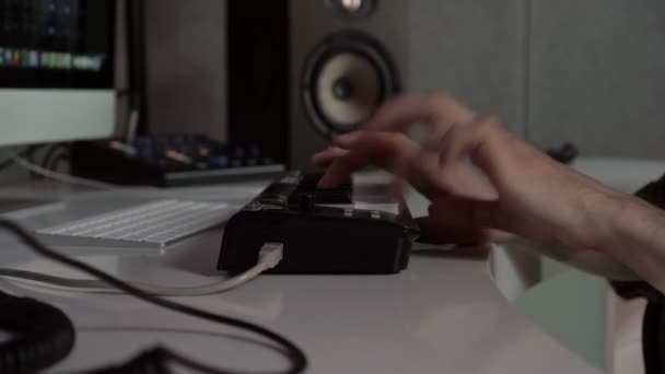 As mãos de perto estão a tocar música no sintetizador. Um compositor masculino trabalha em um estúdio de gravação — Vídeo de Stock