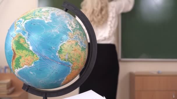 Iskolai földgömb, a tanár ír a táblára. Iskolai oktatás — Stock videók