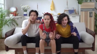 Mutlu Avustralyalı taraftarlar TV 'de maç izleyip zafere seviniyorlar. Avustralya bayrağı taşıyan futbol taraftarları