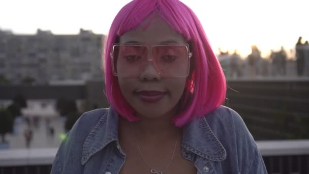 Retrato de uma jovem negra africana com cabelo rosa em um fundo de pôr do sol — Vídeo de Stock