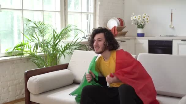 Italienska fan med flagga tittar på sport eller fotboll hemma — Stockvideo