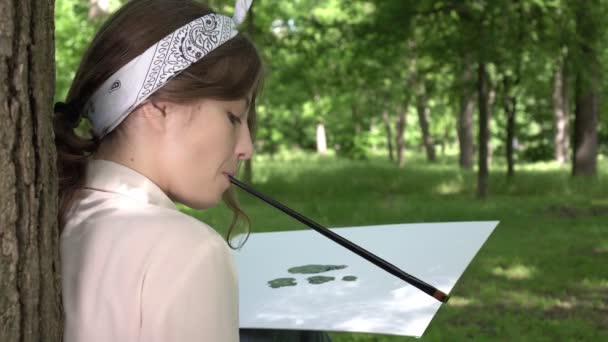 Mladá žena umělec maluje stromy na plátno v parku — Stock video