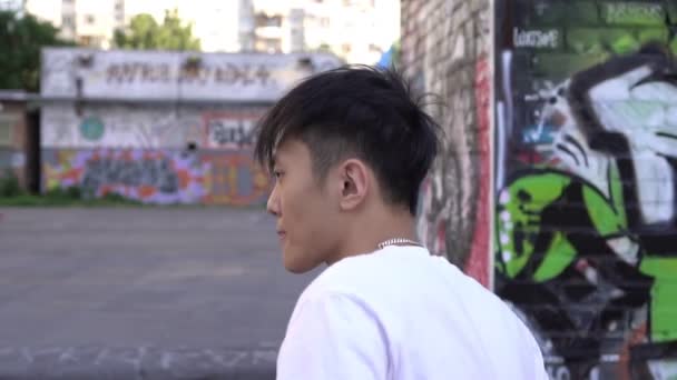 Genç Asyalı adam dışarıda dans ediyor. Mtransient sokak dansçısı, ağır çekim. Hip hop ve break dans kültürü — Stok video