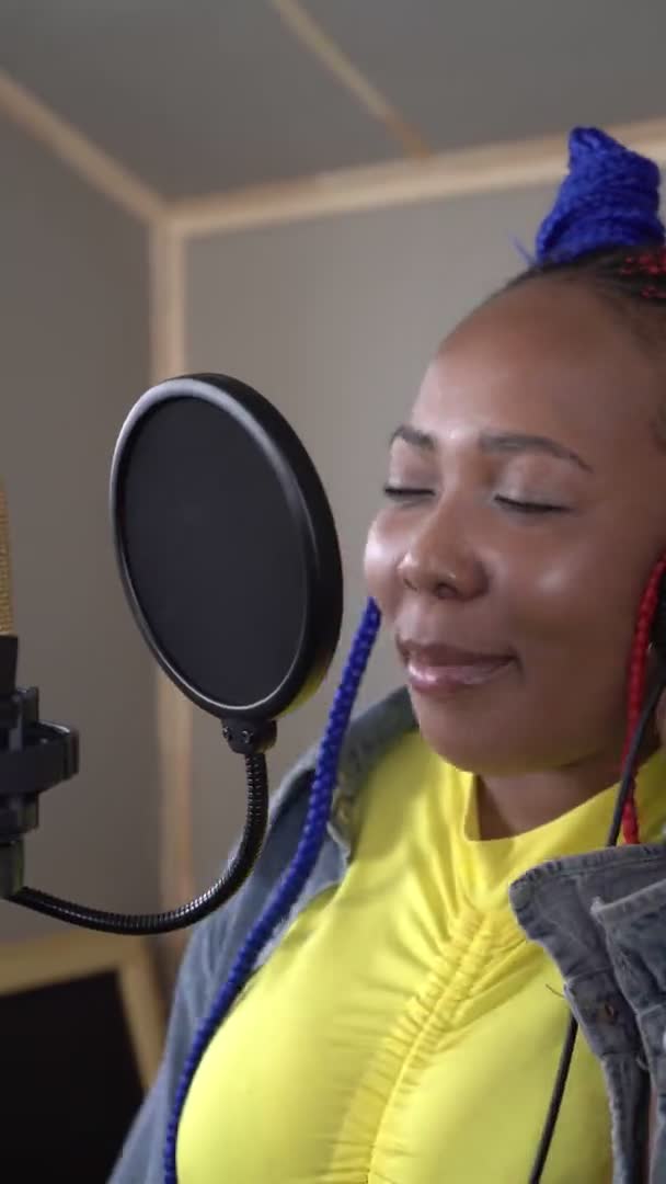 Dikey video: Genç siyahi bir kadın şarkıcı bir kayıt stüdyosunda şarkı kaydediyor — Stok video