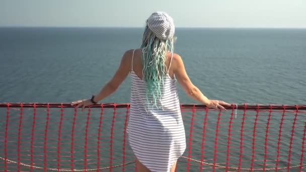 Mulher atraente olha para o mar do convés de observação — Vídeo de Stock