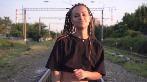 Jovem mulher elegante caminha e dança na estrada de ferro. Jovens, mulher adolescente ao ar livre — Vídeo de Stock