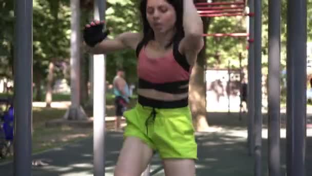 Mulher entra para esportes e exercícios ao ar livre. Uma mulher treina num local de treino. A esportista envolve-se na aptidão — Vídeo de Stock