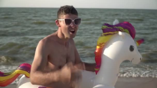 Cheerful funny crazy man in an inflatable swimming ring on the sea beach — Stockvideo