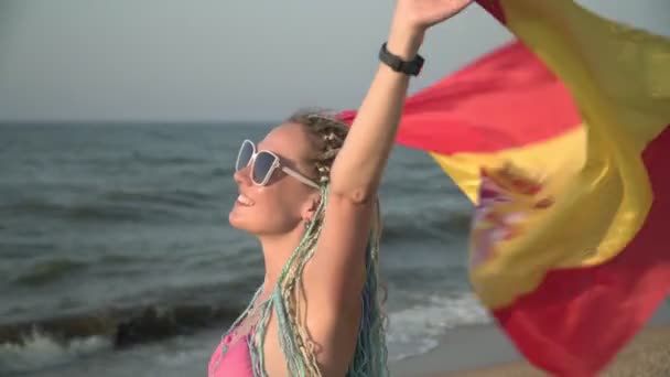 Jovem mulher atraente com a bandeira da Espanha na praia do mar — Vídeo de Stock