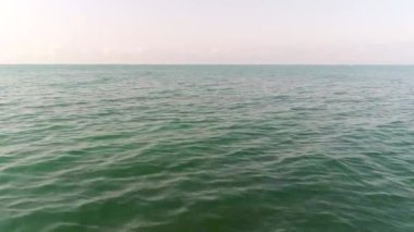 Sakin yeşil deniz ya da okyanus güneşli bir günde berrak bir gökyüzünün arka planında