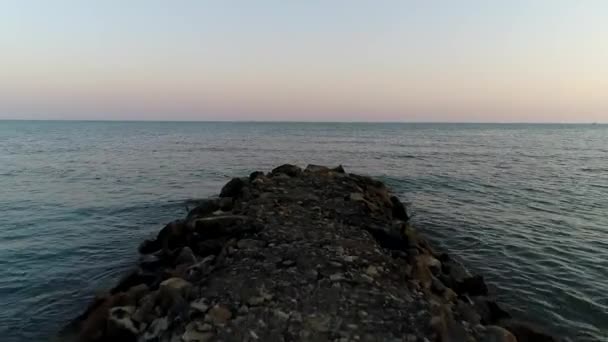 Πέτρα breakwater ή προβλήτα με φόντο το βράδυ της θάλασσας. Όμορφο θαλάσσιο υπόβαθρο — Αρχείο Βίντεο