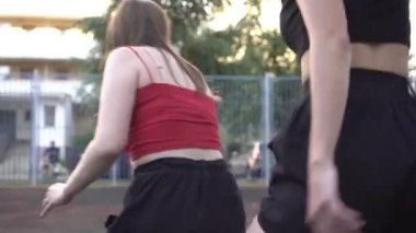 Kadınlar dışarıda basketbol oynarlar. Genç aktif kadınlar spor için içeri girer ve sokakta basketbol oynarlar.