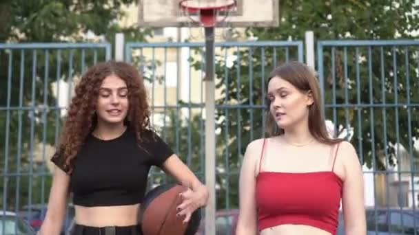 Jeunes amies heureuses sur le terrain de basket à l'extérieur. Amis adolescents après l'entraînement sportif. Concept d'amitié féminine — Video