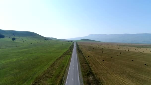 Landstraße, Feld mit Heuhaufen, ländliche Landschaft, Luftaufnahme. Autobahn mit rustikalem Hintergrund — Stockvideo