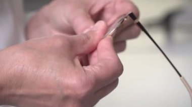Bir optometrist laboratuvarda gözlük yapar. Optometri, bireysel lens ve gözlük üretimi