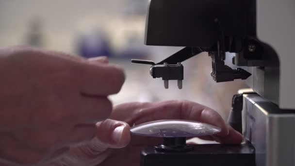 An optometrist makes eyeglass lenses in a laboratory. The science of optometry — Stock Video