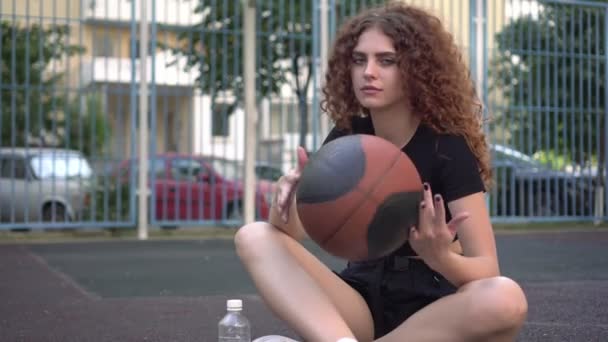 Młoda seksowna kobieta z koszykówką na boisku do koszykówki. Młodzież sportowa. — Wideo stockowe