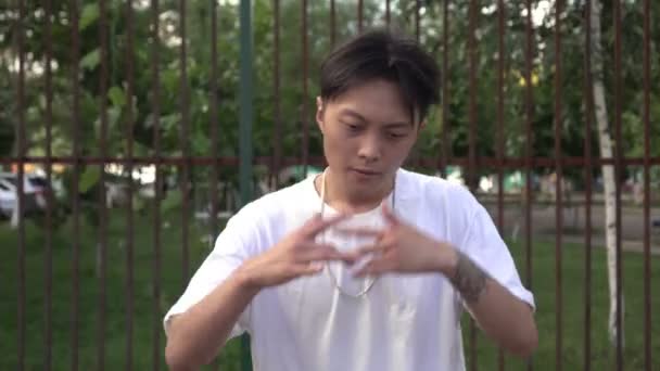 Jovem asiático homem dançando breakdance ou hip-hop ao ar livre — Vídeo de Stock