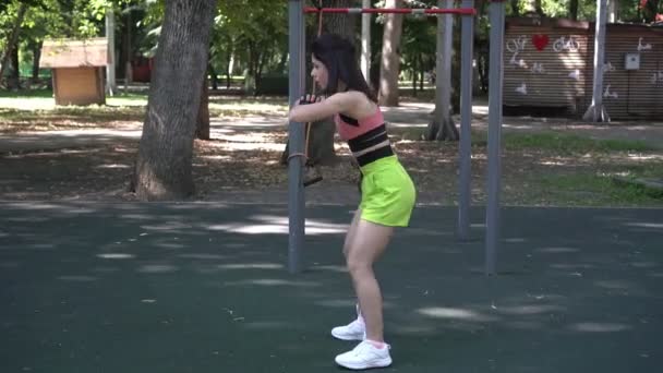 Fiatal sportoló nő gyakorlása, guggolás és csinál fitness szabadban — Stock videók
