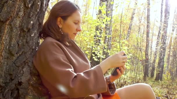 Chica jugando con el teléfono en el parque — Vídeo de stock