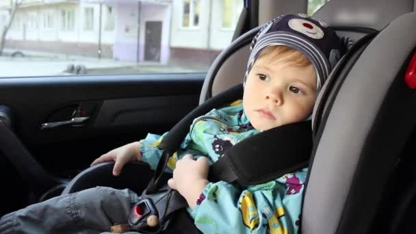 Niño en el asiento del coche de los niños en los paseos en coche — Vídeos de Stock