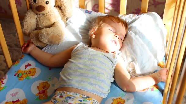 Schlafendes Baby mit Decke in der Krippe — Stockvideo