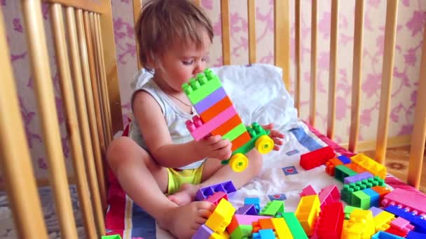 Kind spielt Bauarbeiter im Kinderbett — Stockvideo