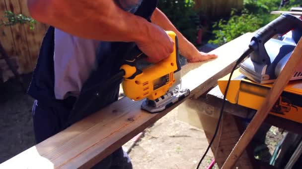 Man aan het werk met een machtshulpmiddel op hout — Stockvideo