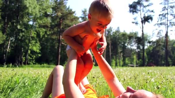 Mamá con un niño jugando en el prado en el parque — Vídeos de Stock