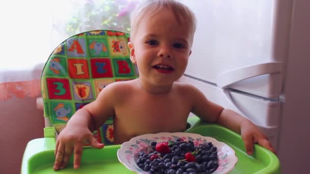 Ребенок ест спелые ягоды — стоковое видео