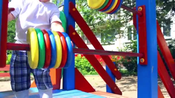 Uma criança brinca no parque infantil — Vídeo de Stock