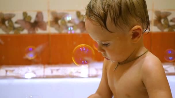 Ett barn leker i badet med såpbubblor — Stockvideo