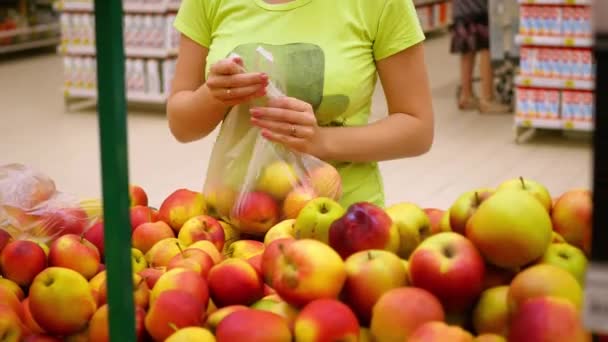 Menina pega maçãs no supermercado — Vídeo de Stock