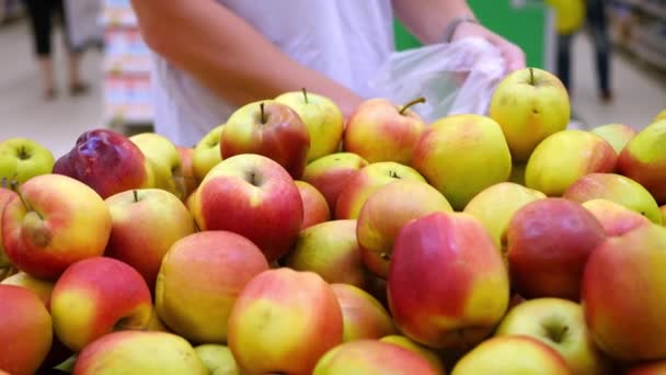 Een man haalt appels in de supermarkt — Stockvideo