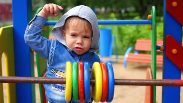 Uma criança brinca no parque infantil — Vídeo de Stock