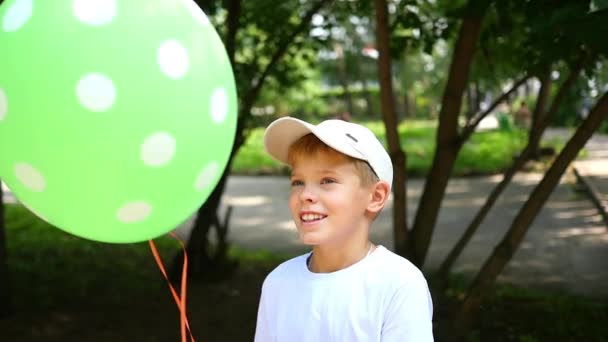 Ребенок играет в парке с воздушным шаром — стоковое видео