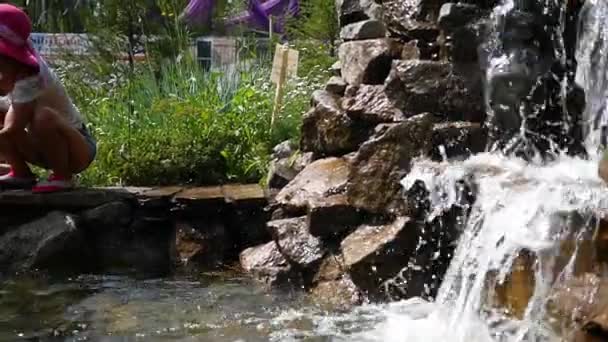 Une femme avec un enfant marchant près de la fontaine — Video