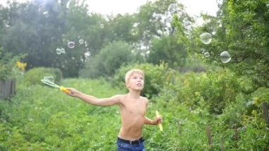 Çocuk açık havada büyük sabun köpüğü yapma
