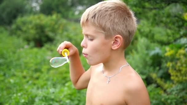 Niño haciendo burbujas de jabón al aire libre — Vídeos de Stock