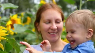 çiçek ile oynarken onun anneler kollarında çocuk