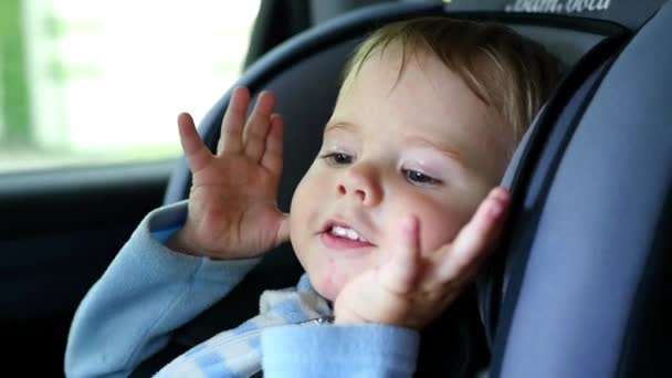 Ребенок едет в машине и смеется — стоковое видео