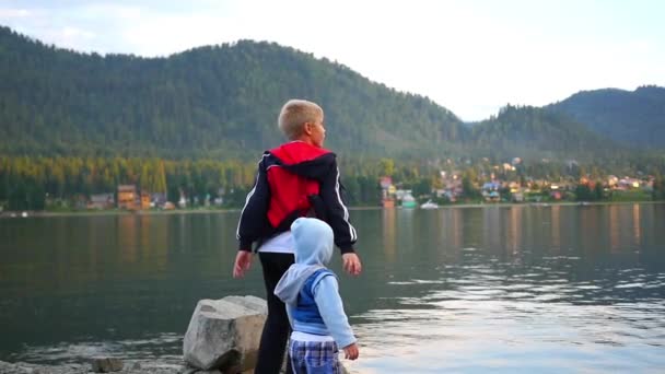 Enfants jetant des pierres dans la rivière — Video