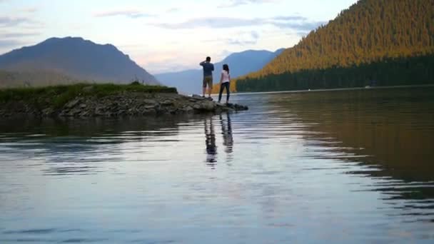 Couple amoureux marchant sur la rivière au coucher du soleil — Video