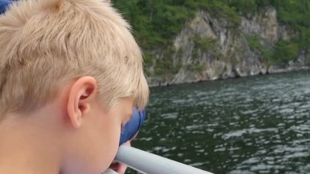 Kind blazen van zeepbellen in de buurt van het water — Stockvideo