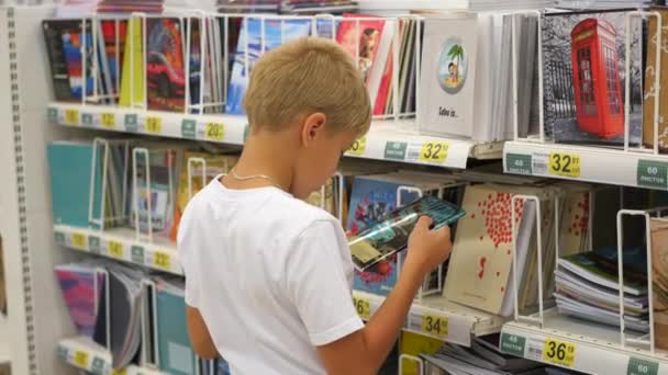 Νοβοσιμπίρσκ, Ρωσική Ομοσπονδία - Ιούλιος 31,2016: το παιδί στο κατάστημα επιλέγει copybooks — Αρχείο Βίντεο