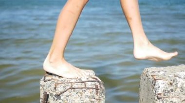 bir çocuk beton yığınları üzerinde çalışır