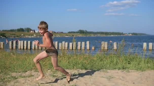 Ребенок бегает по пляжному песку — стоковое видео